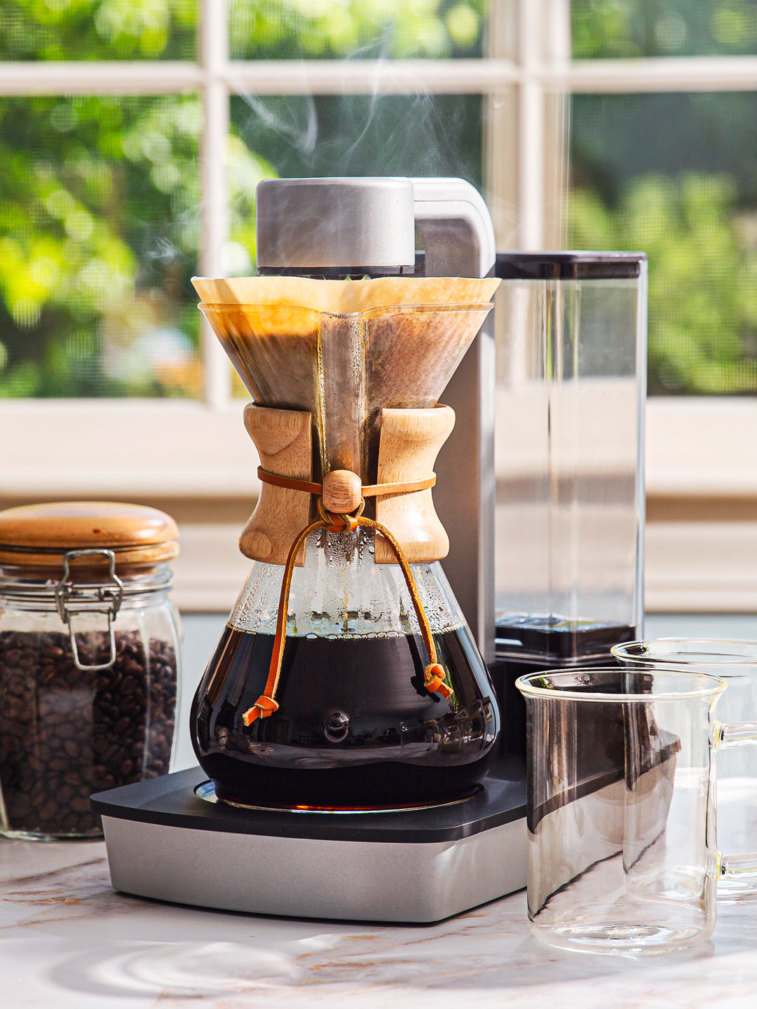 Ottomatic coffeemaker brewing hot coffee on a kitchen counter