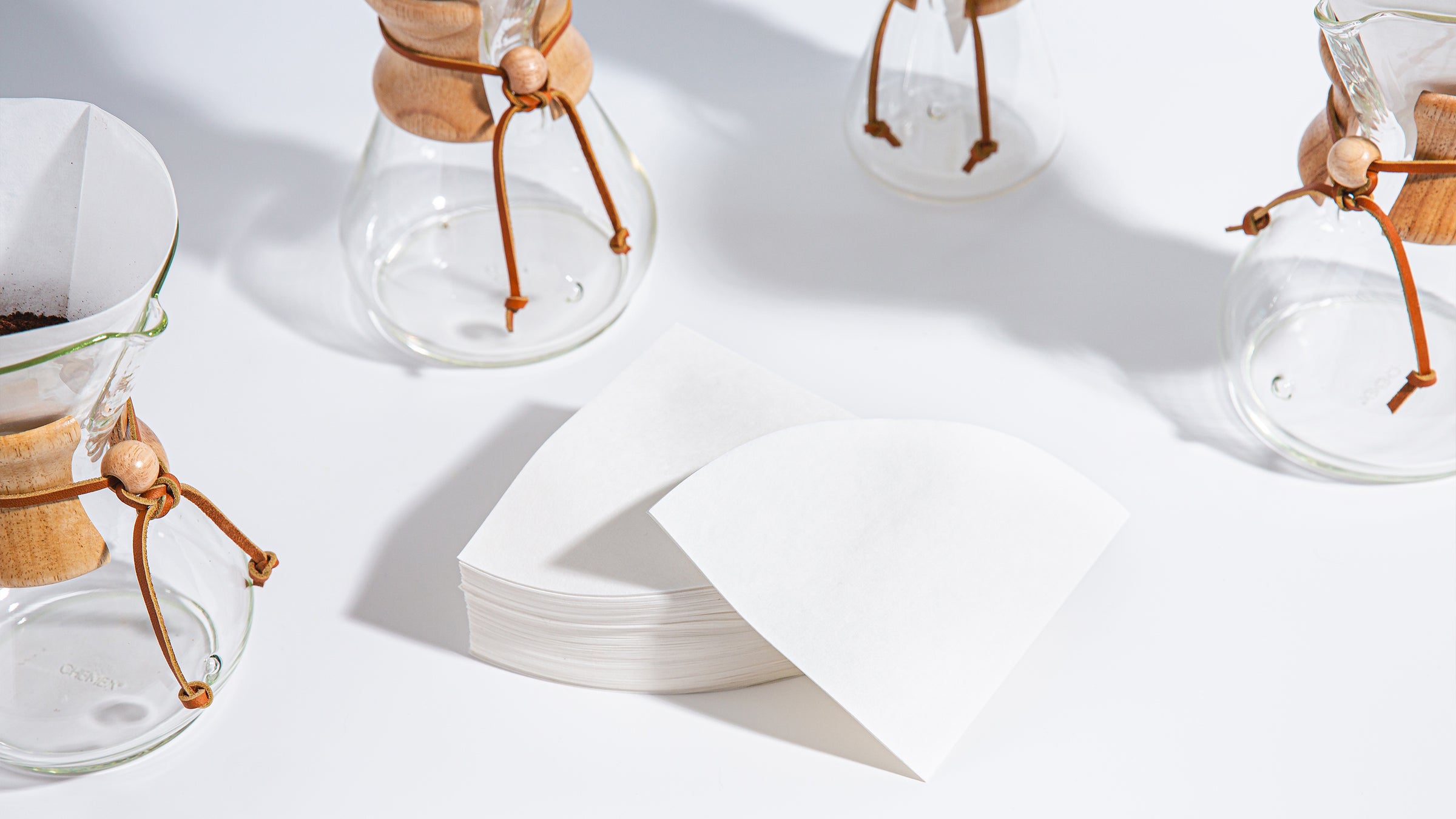 Chemex circle filters surrounds by empty coffeemakers