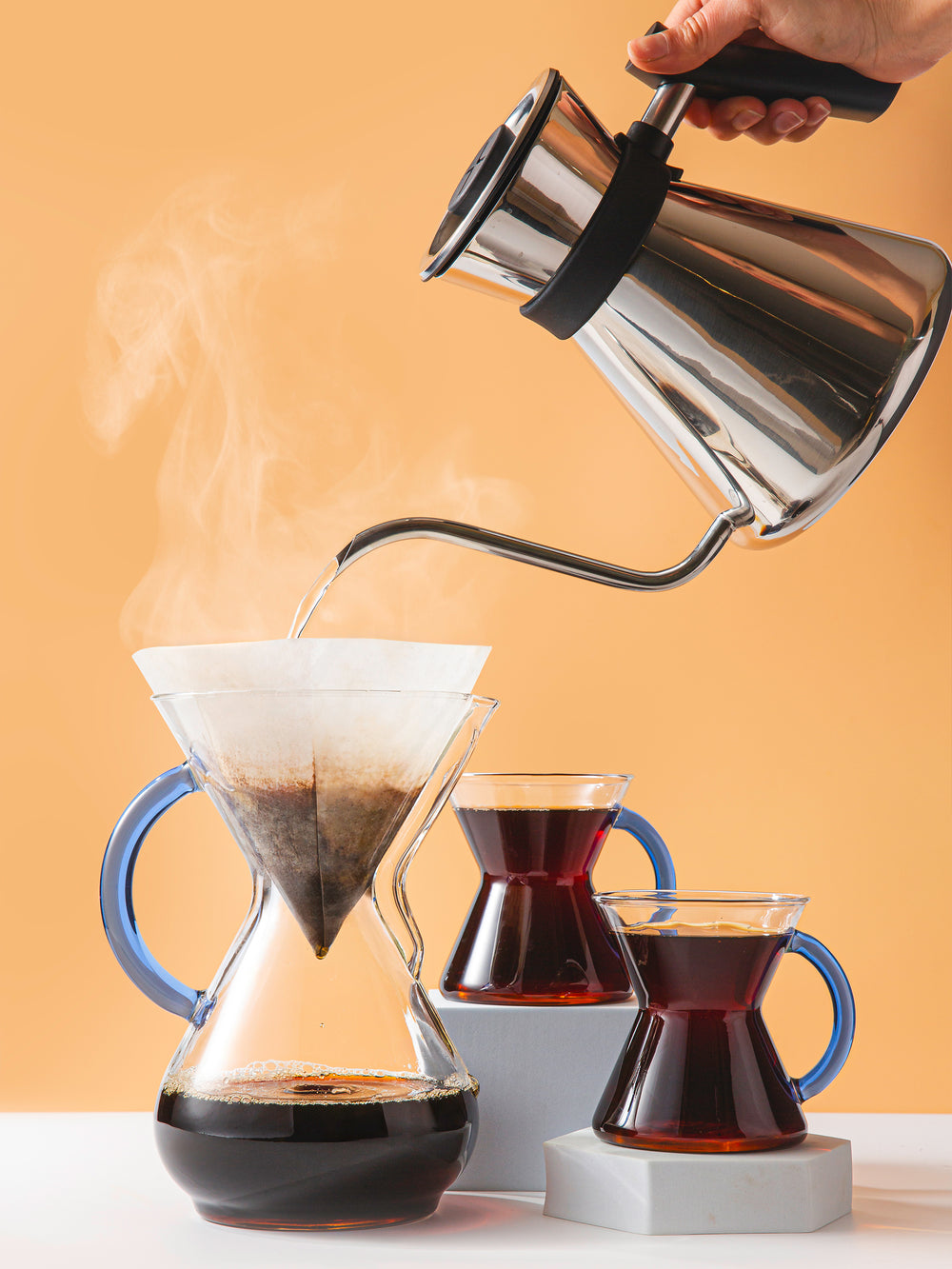 Chettle brewing into a six cup sapphire glass handle CHEMEX, two coffee filled Sapphire glass handle mugs sit to the side