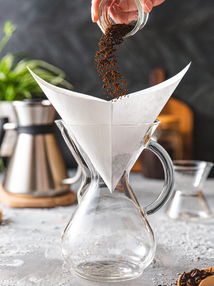 Pouring coffee grounds into a Chemex Bonded white square filter