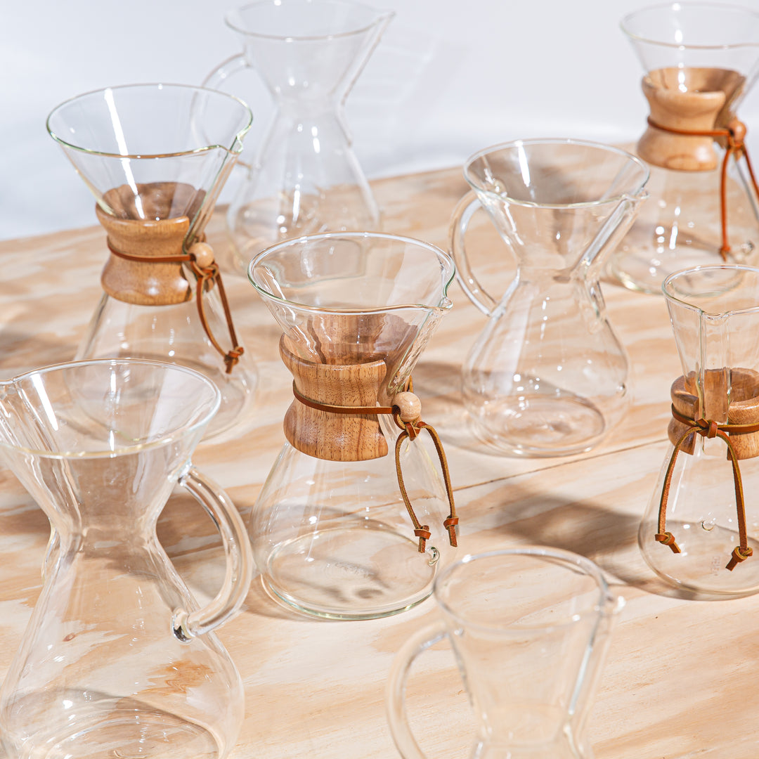 Series of coffeeemakers lined up next to each other on a wooden table
