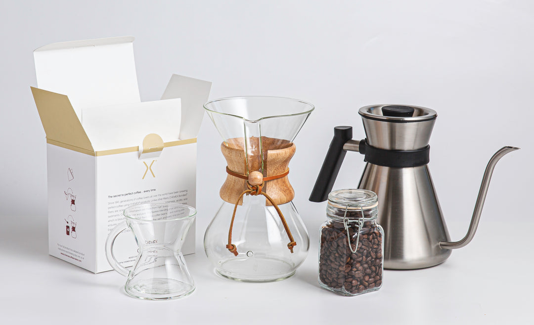 Open box of filers, glass handle mug 6-cup classic Chemex container of coffee beans and the Chemex Chettle