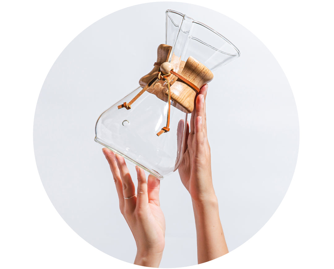 hands holding up a chemex 8-cup classic