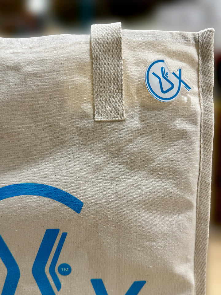 CX symbol acrylic pin pinned on a tote bag