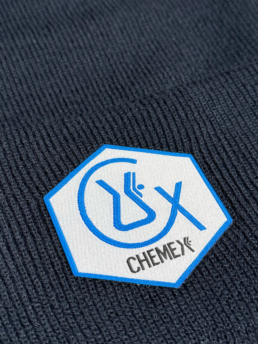 Chemex chemist winter hat closeup on the woven patch that is attached to the hat 