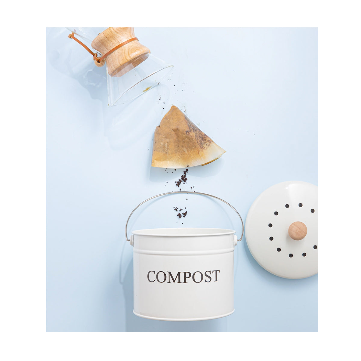 coffee pot dumping a used coffee filter into a compost bucket.