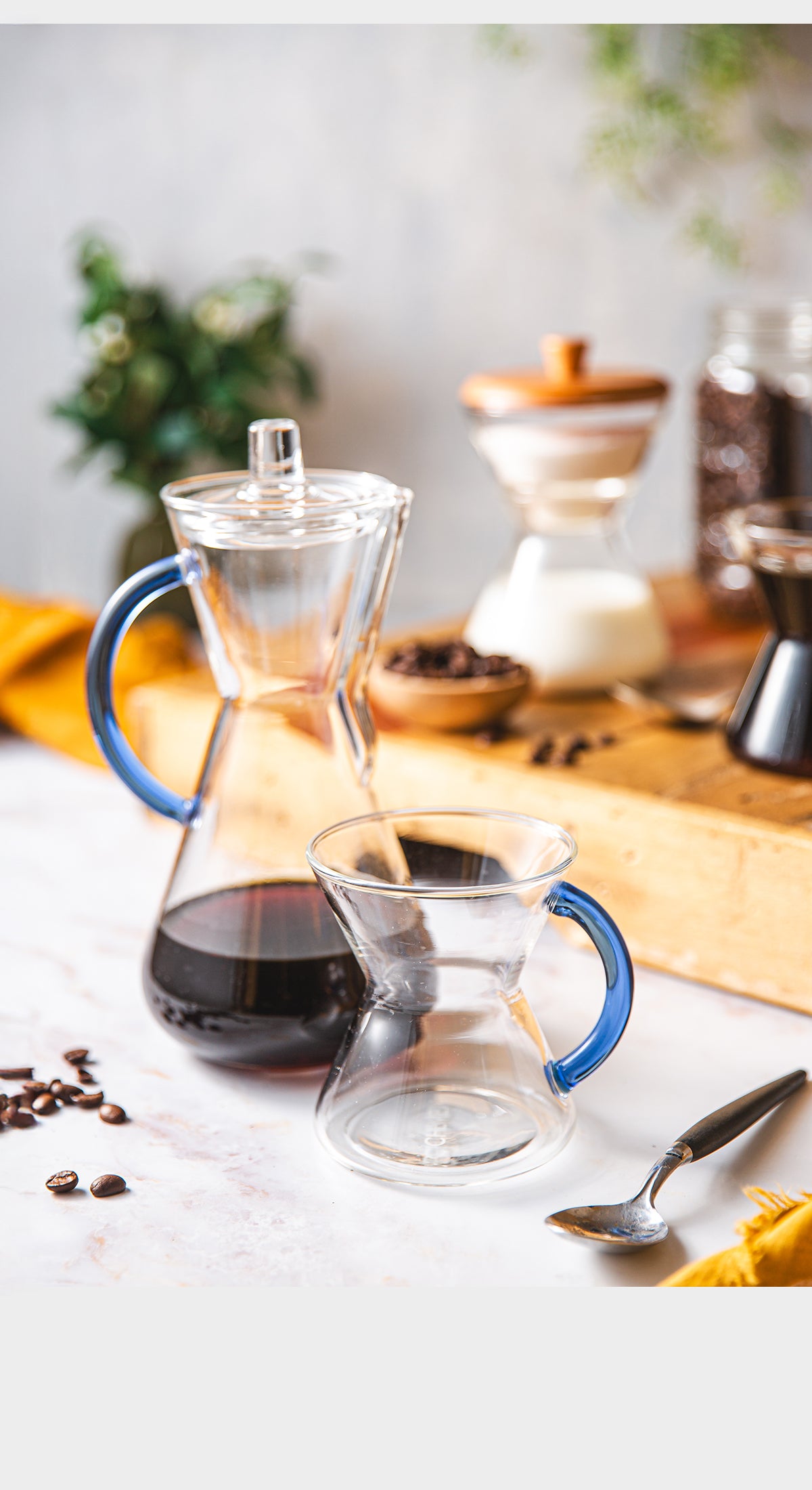 Coffee-making setup with a carafe and glass mug on a table.
