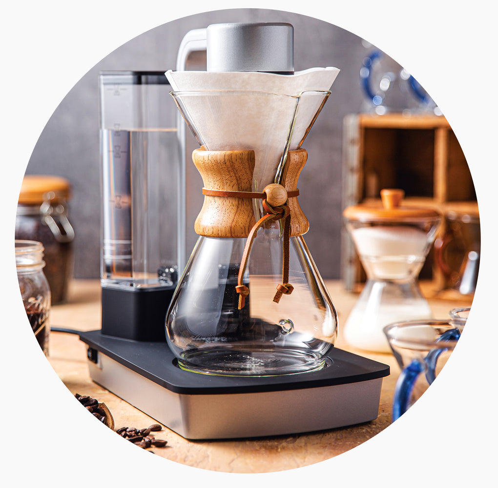 Glass coffee maker with wooden collar on a wooden surface