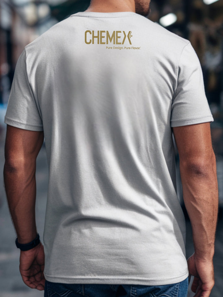Person wearing a white t-shirt with 'Chemex' logo on the back, blurred background